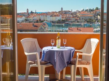 yellow apartment, balcony with a view of the sea and the town of Rab, table and chairs