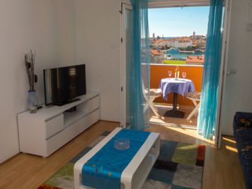 blue apartment, living room, LCD TV with satellite channels, sofa, dining room, view of the old town of Rab